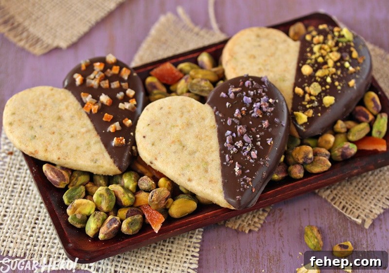 Pistachio Shortbread Cookies Pistachio Shortbread Cookies - Three shortbread cookies displayed on a tray with pistachios. | From SugarHero.com