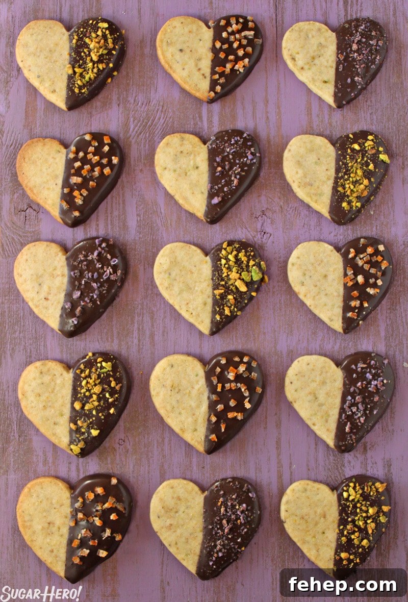 Pistachio Shortbread Cookies Pistachio Shortbread Cookies - 15 cookies displayed in rows. The cookies are half covered in chocolate and topped with pistachios. | From SugarHero.com