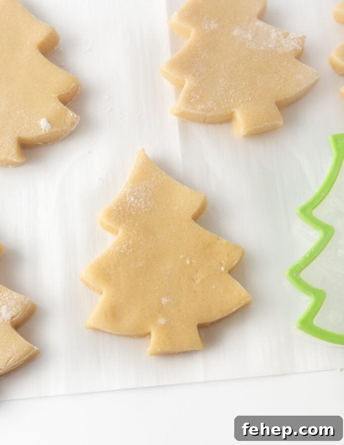cut out sugar cookie dough in christmas tree shape