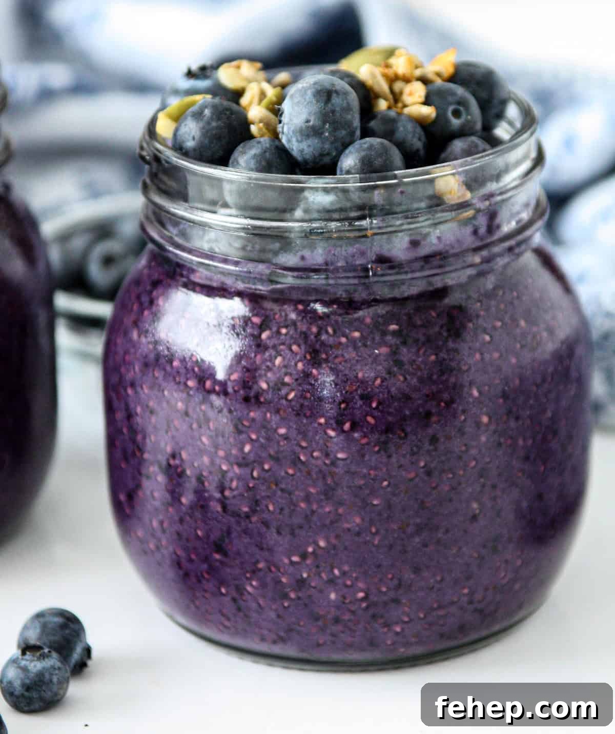 Blueberry chia pudding in a glass jar, topped with fresh blueberries and granola.