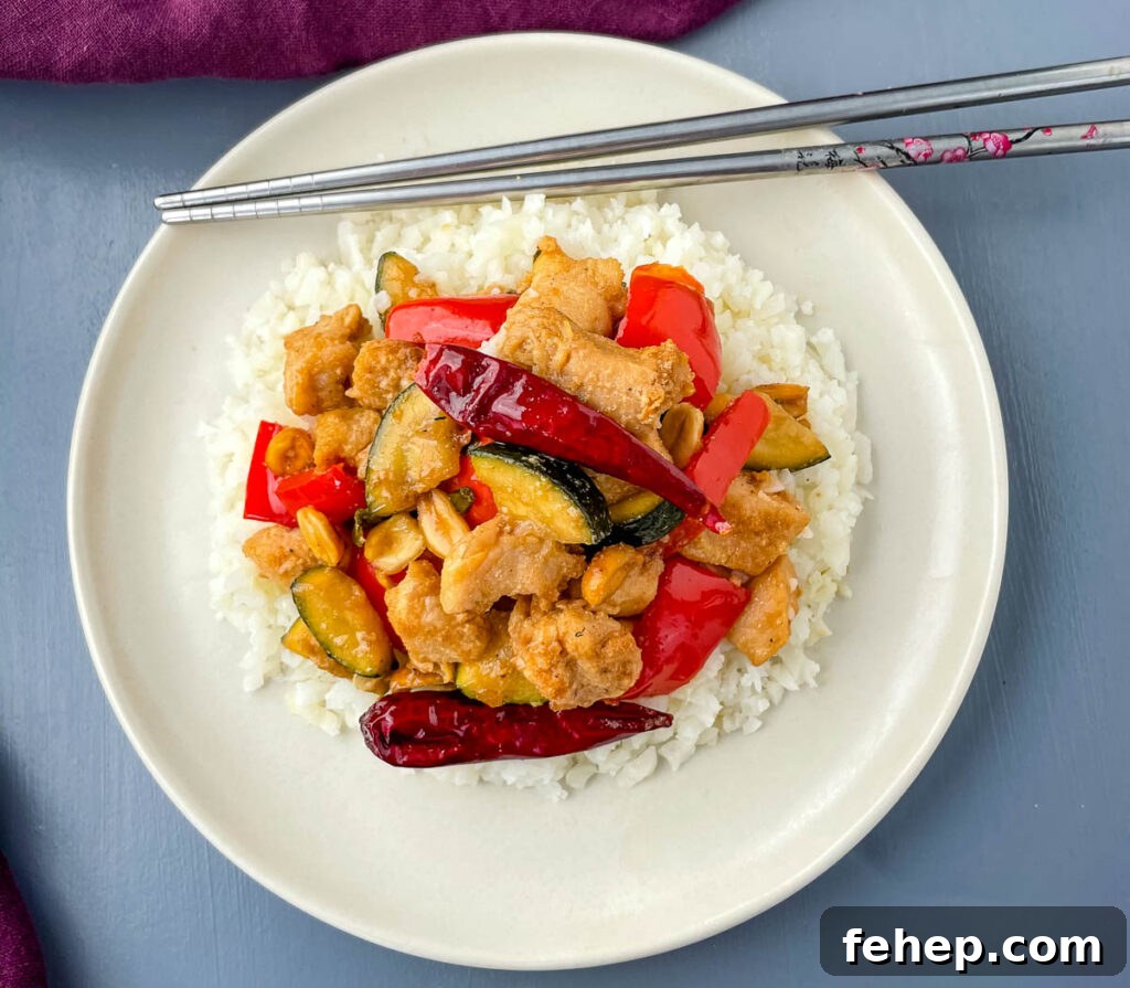Panda Express copycat kung pao chicken on a white plate with chopsticks