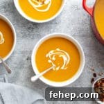 Overhead shot of bowls of healthy sweet potato soup on the countertop with a pot alongside.
