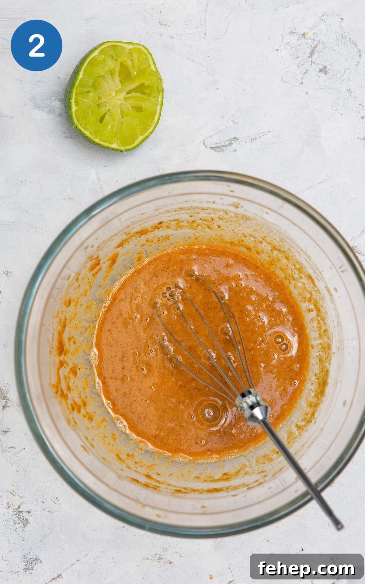 peanut butter, tamari, sesame oil and lime sauce in a bowl on white marble background.