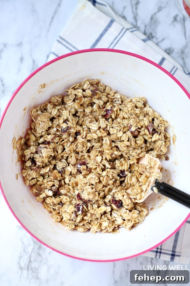 Cranberry Granola Bar Squares are a nutritious, moist, chewy granola bar square filled with oats, crispy rice, and dried cranberries. This is an easy, delicious, gluten-free and dairy-free snack recipe kids love!