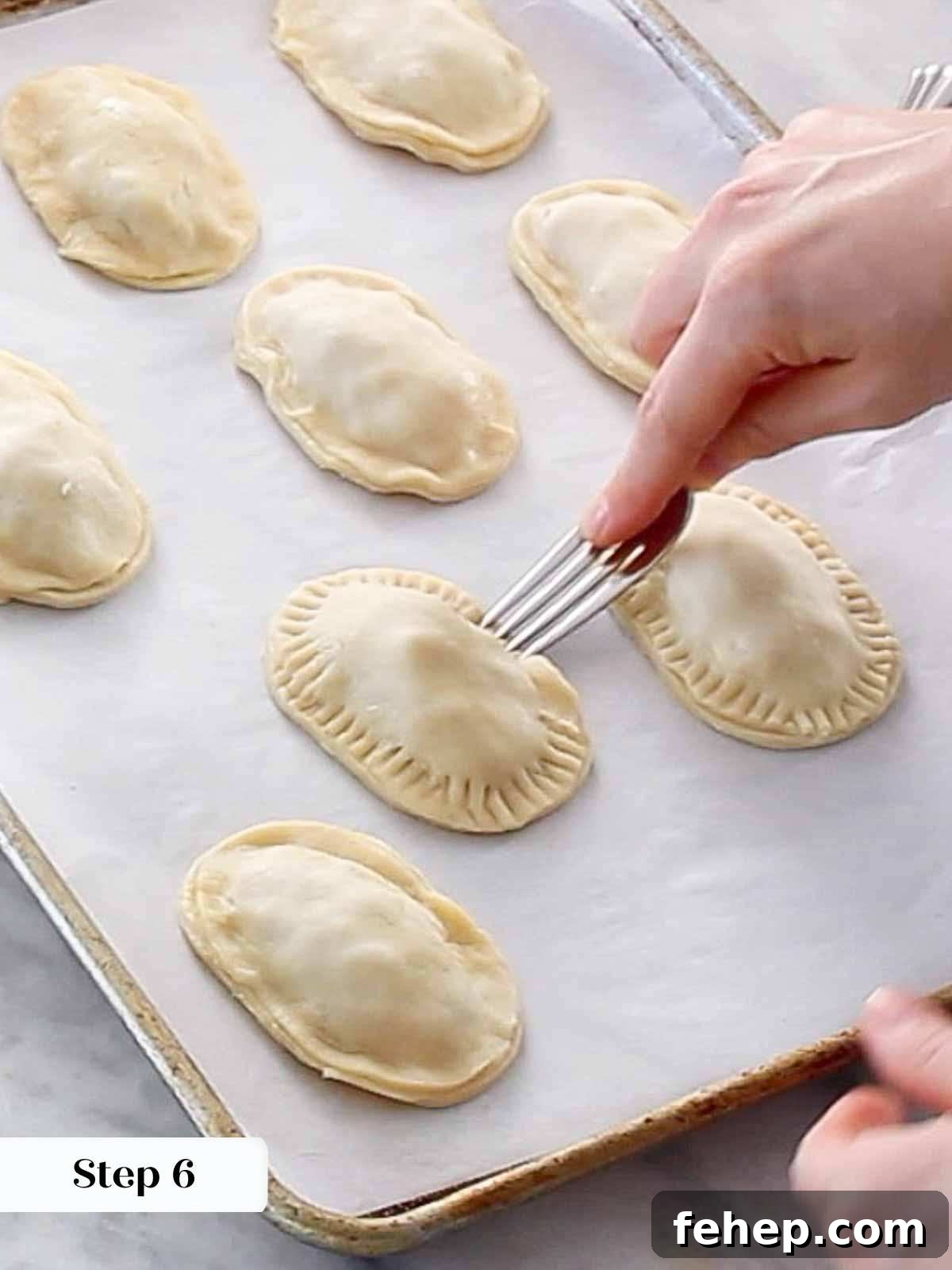 Mini Apple Hand Pies: Flaky Pocket Pies with Cinnamon Filling 10 sealing hand pies with fork.