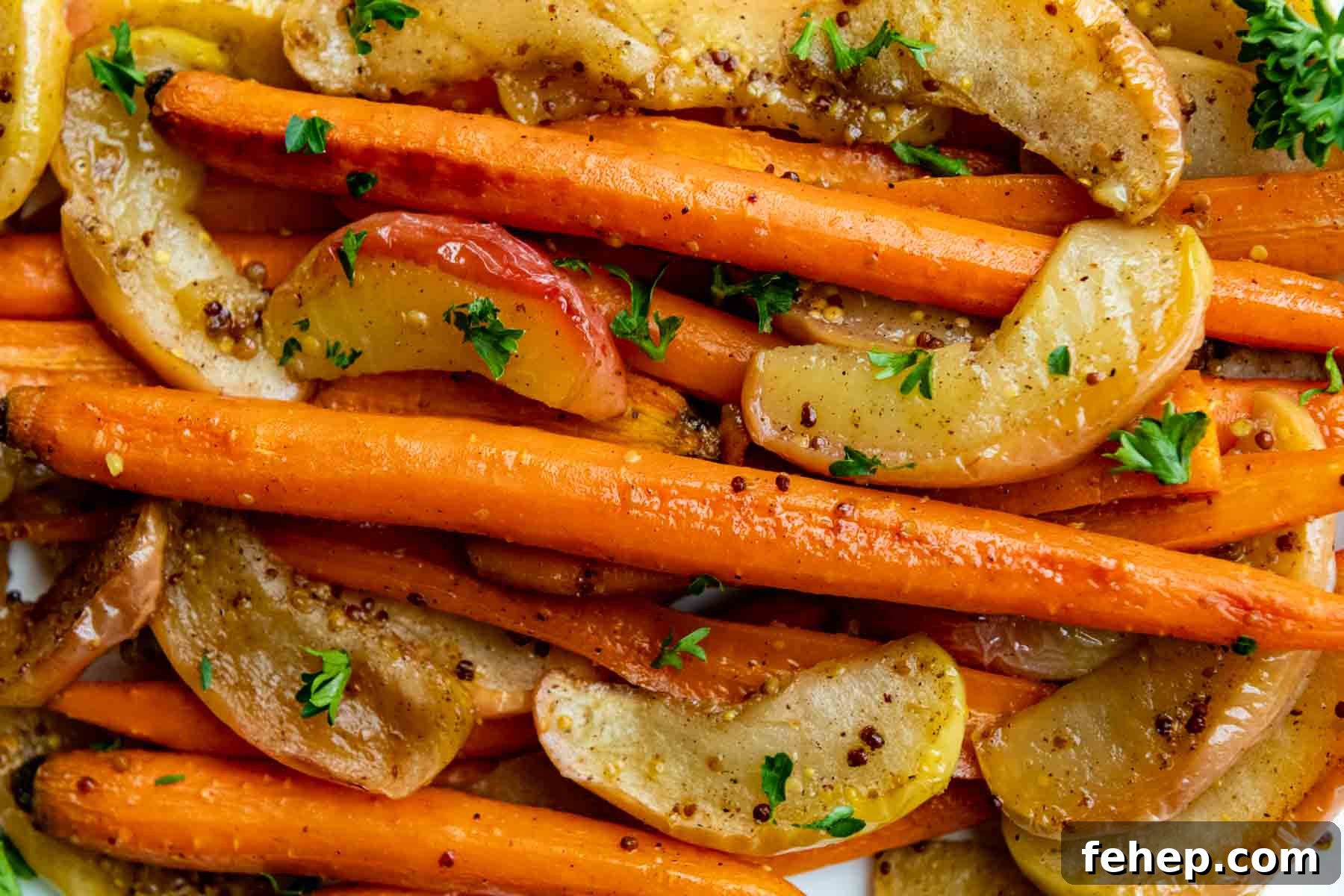 Maple Dijon Roasted Carrots and Apples with Honey Glaze 5 carrots and apples close up with parsley sprinkled on top.