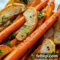 Maple Dijon Roasted Carrots and Apples with Honey Glaze 6 carrot apple side dish on a white plate.