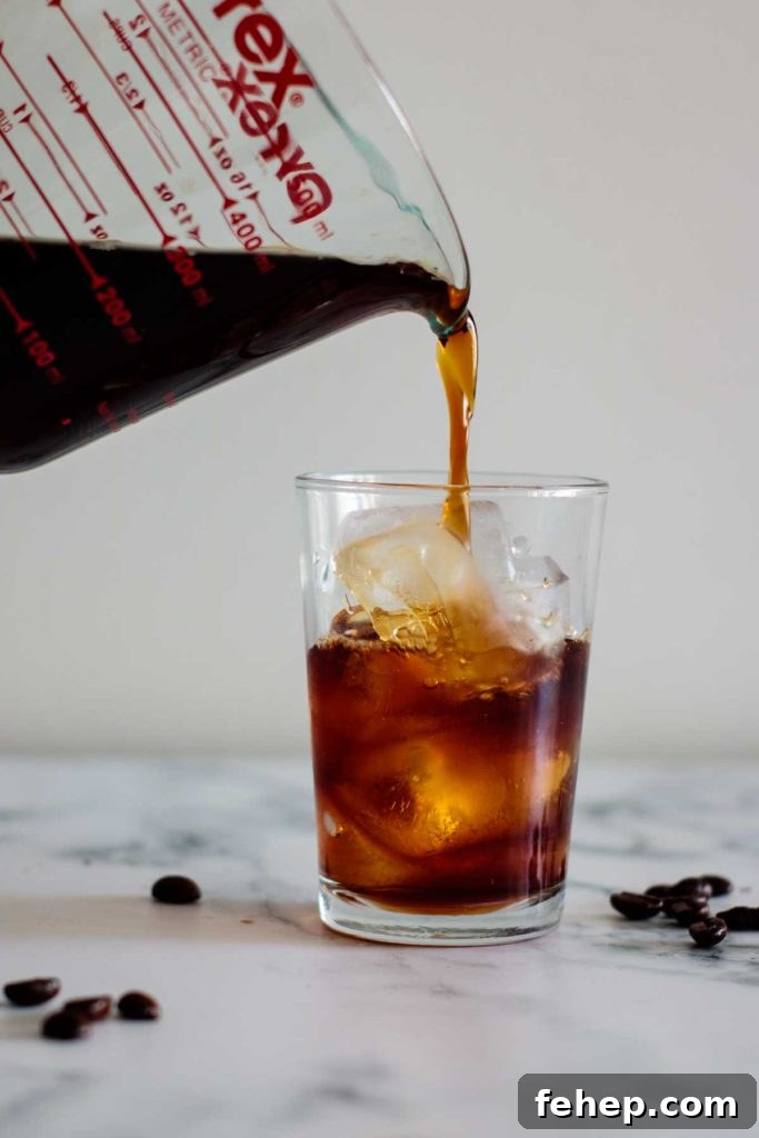 Cold Brew Coffee Concentrate: Ratios, Methods, and Pro Tips 12 cold brew coffee being poured into a cup filled with ice