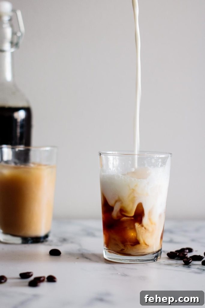 Cold Brew Coffee Concentrate: Ratios, Methods, and Pro Tips 4 milk pouring into a cup, with a cup and a bottle on the background