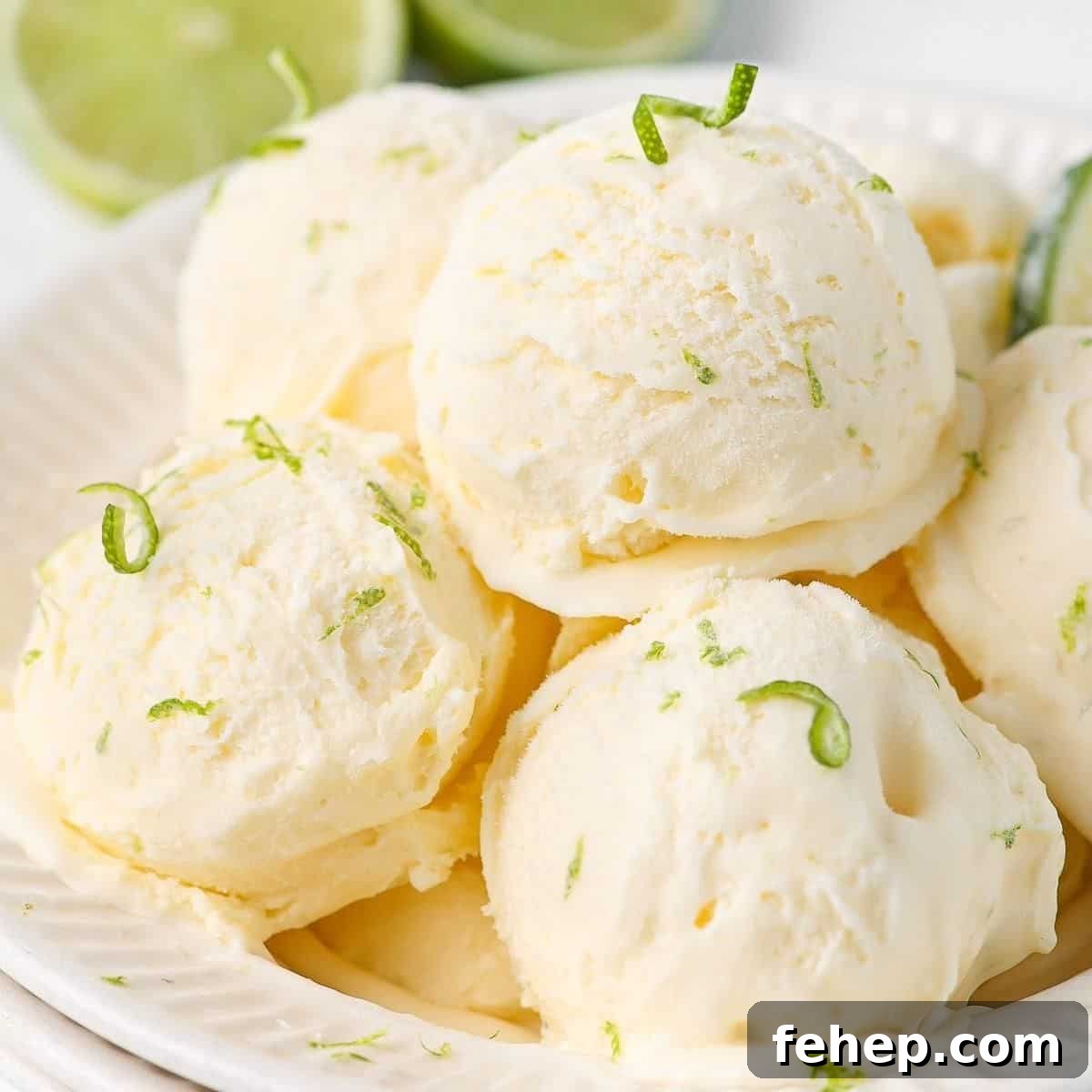 Bowl with several scoops of ice cream, garnished with lime zest.