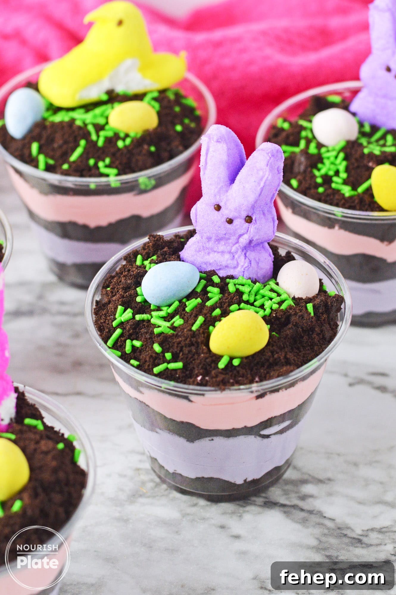 Easter Dirt Cups Dessert Recipe — Fun No-Bake Treats for Kids 6 Easter dirt cups with layered instant pudding in colors, topped with peeps and mini eggs.