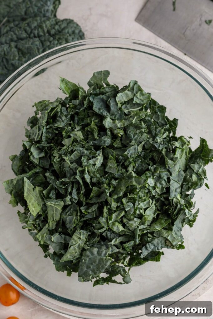 shredded kale in large mixing bowl kale leaves on the side 