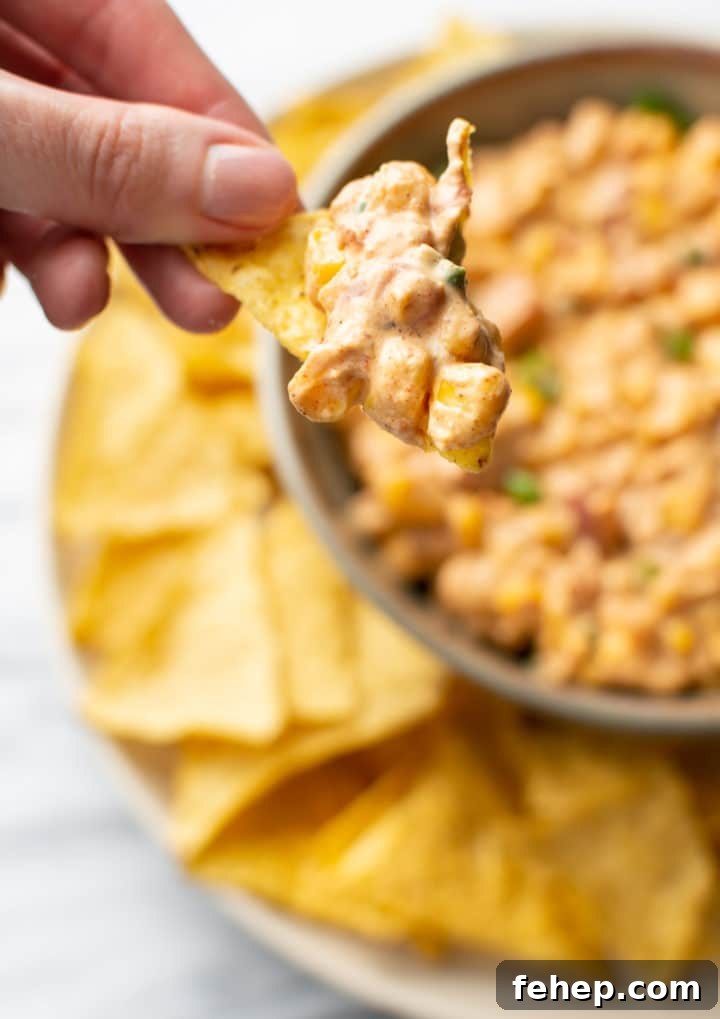 Cream Cheese Corn Dip Recipe for Parties and Game Day 5 tortilla chip scooping out some cream cheese corn dip