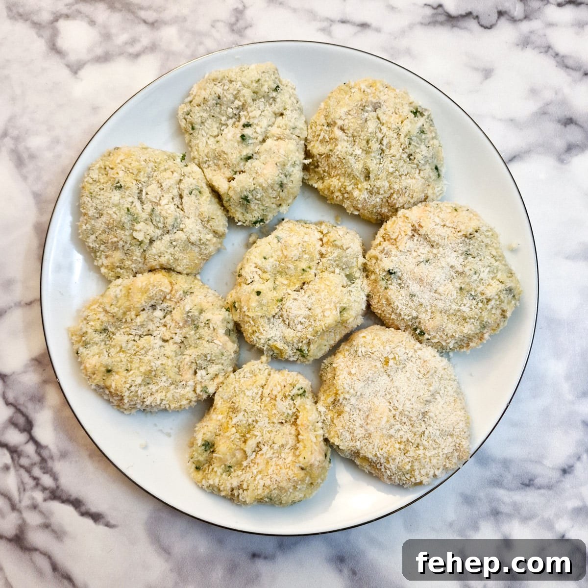 Crispy Salmon Fish Cakes with Lemon-Dill Sauce 13 8 coated salmon fishcakes on a white plate.