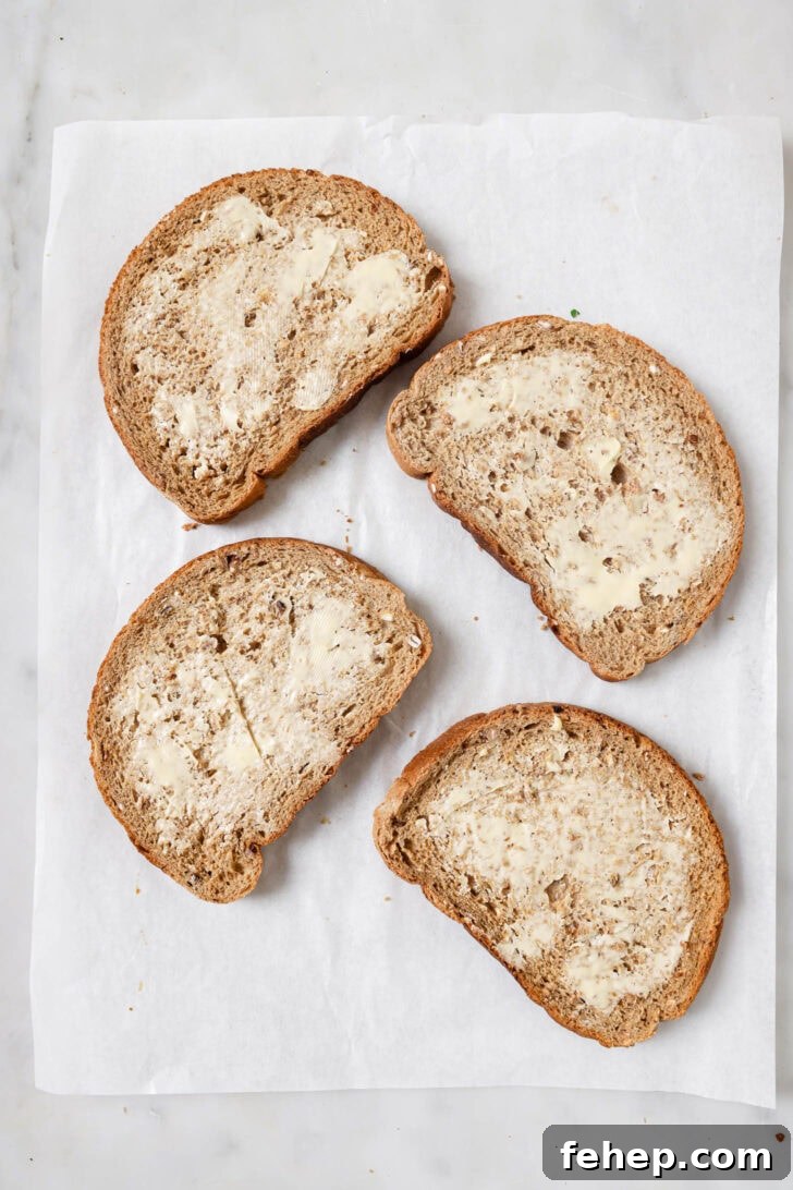 Creamy Chicken Mayo Sandwich Recipe for Balanced Flavor 14 Slices of buttered multigrain bread on a piece of parchment paper ready for making Chicken Sandwiches.