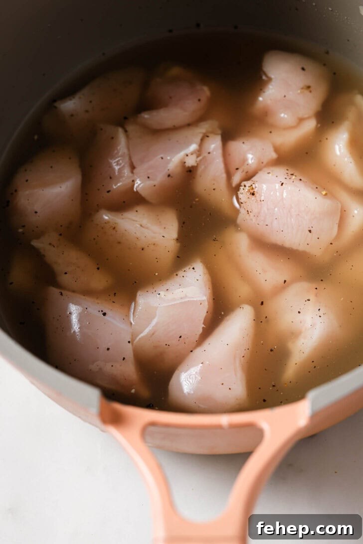 Creamy Chicken Mayo Sandwich Recipe for Balanced Flavor 7 Cubed chicken, salt, pepper and stock in a pot ready to be boiled