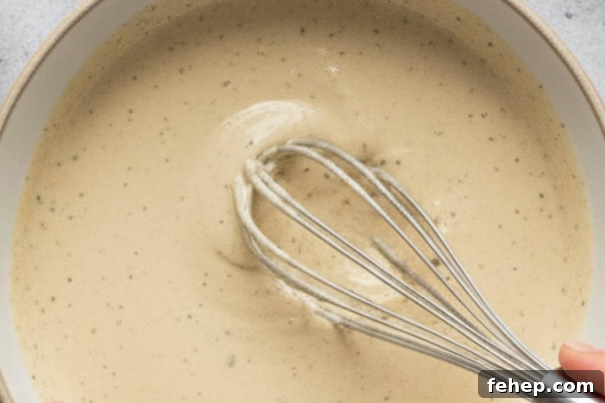 In a small bowl, whisk together mayonnaise, yogurt, olive oil, garlic, anchovies, lemon juice, and parmesan. Season with salt and pepper to taste.