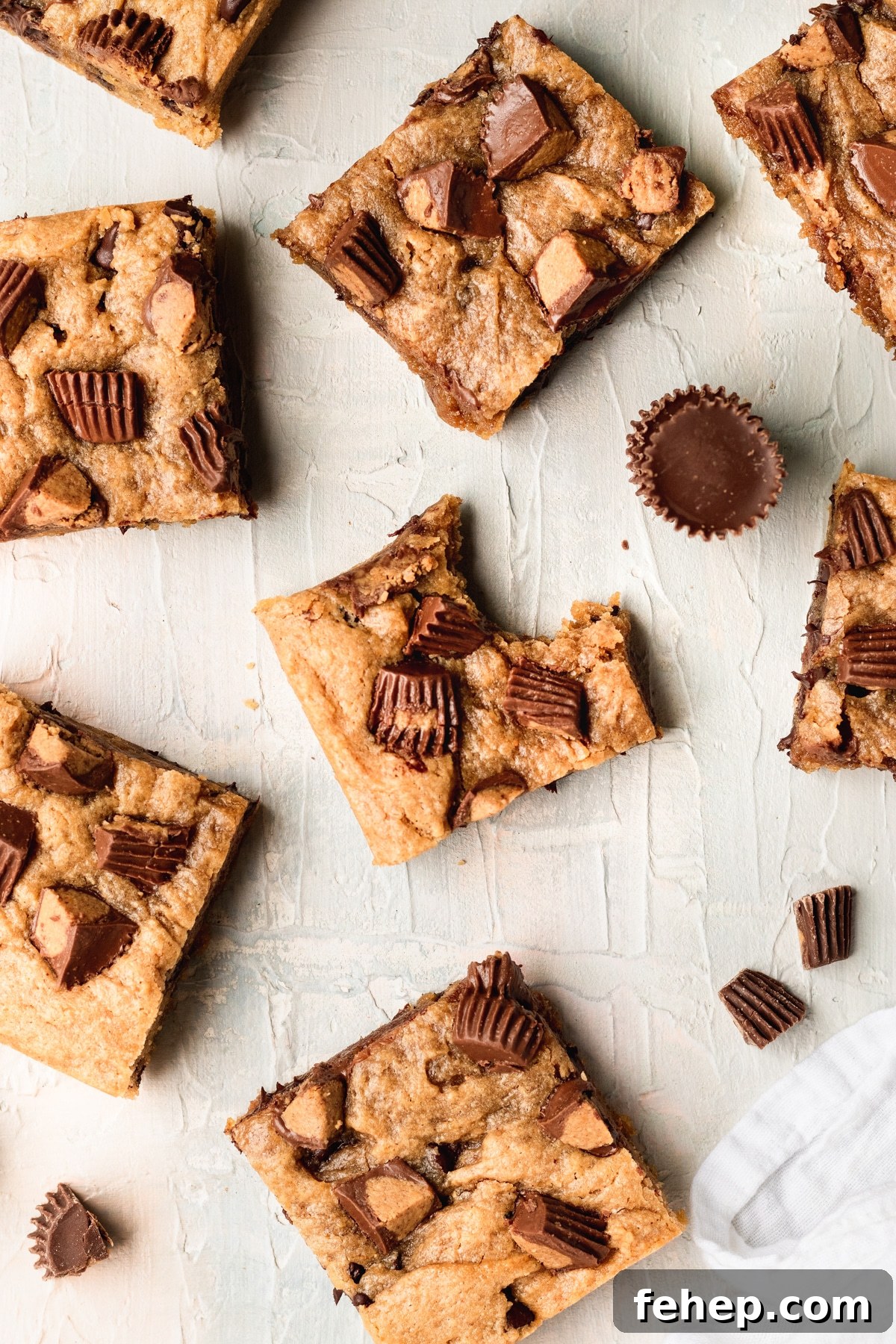 Chewy Peanut Butter Blondies Recipe with Melted Peanut Swirl 2 a bite taken out of a blondie with peanut butter cups on top