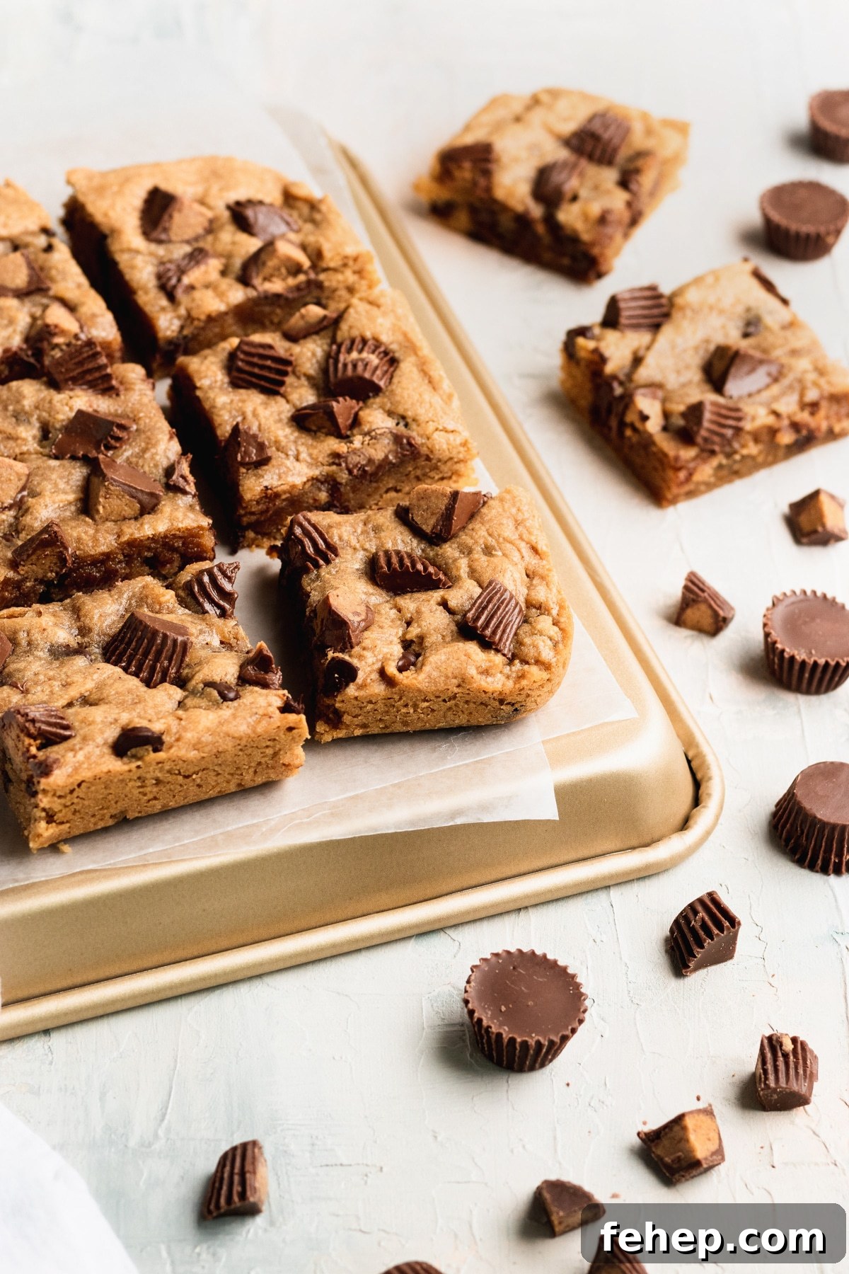 Chewy Peanut Butter Blondies Recipe with Melted Peanut Swirl 6 blondies cut into bars on a gold baking sheet lined with parchment paper