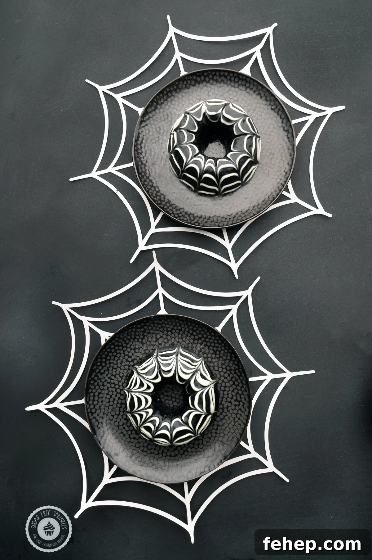 Keto Chocolate-Glazed Donuts for Halloween Treats 2 Chocolate glazed keto donuts with a spider web design on dark black plates with white paper spider webs