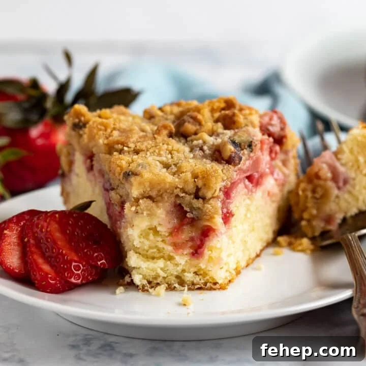 Strawberry Cake on a plate with a bite taken out revealing the inside of the cake.