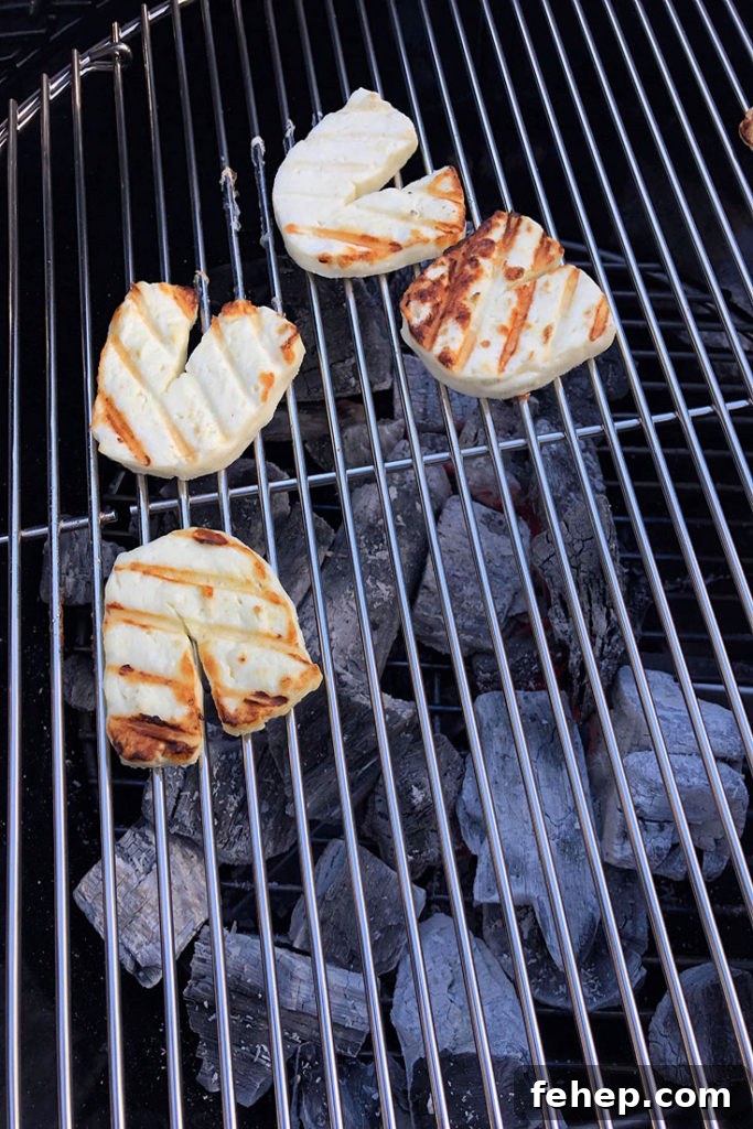 Grilled halloumi cheese slices cooking on a grill.