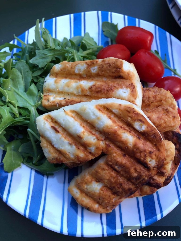 Freshly grilled slices of halloumi cheese on a bed of arugula and baby tomatoes.