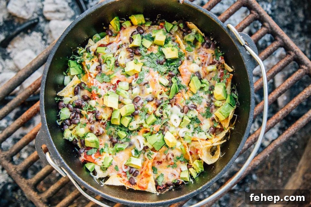 Gluten-Free Camping Meal Ideas for Delicious Outdoor Cooking 11 a cast iron pot filled with nacho's topped with avocado pieces, over a fire