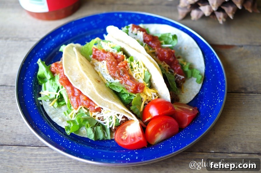 Gluten-Free Camping Meal Ideas for Delicious Outdoor Cooking 4 three tacos on a blue plate with sliced tomotoes
