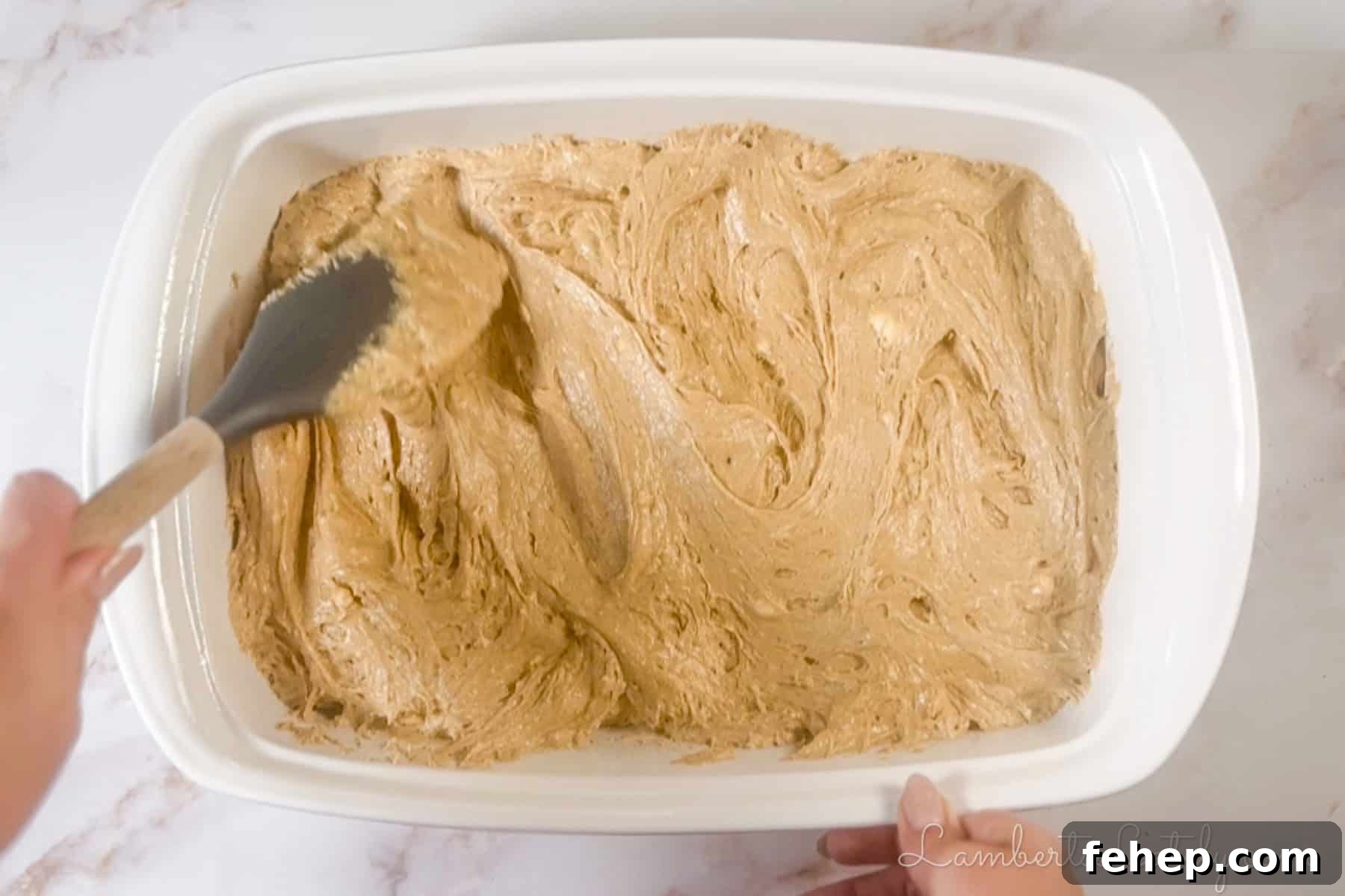 Creamy Eggnog Poke Cake Recipe for Holiday Gatherings 4 spreading spice cake batter in a baking dish.