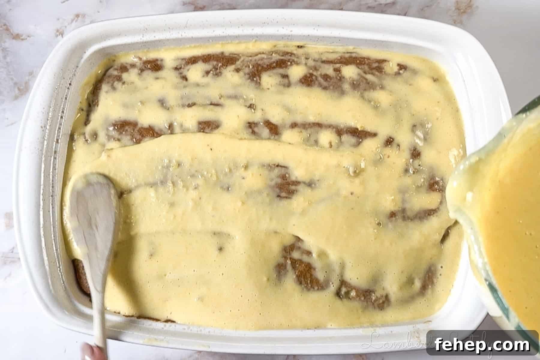 Creamy Eggnog Poke Cake Recipe for Holiday Gatherings 6 pouring eggnog pudding mixture over the cake with holes.