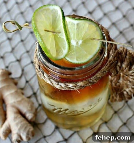 Top view of a Dark and Stormy drink in a mason cup with limes
