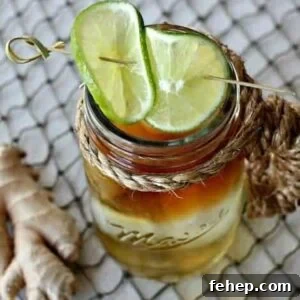 A Dark and Stormy drink in a mason cup with limes