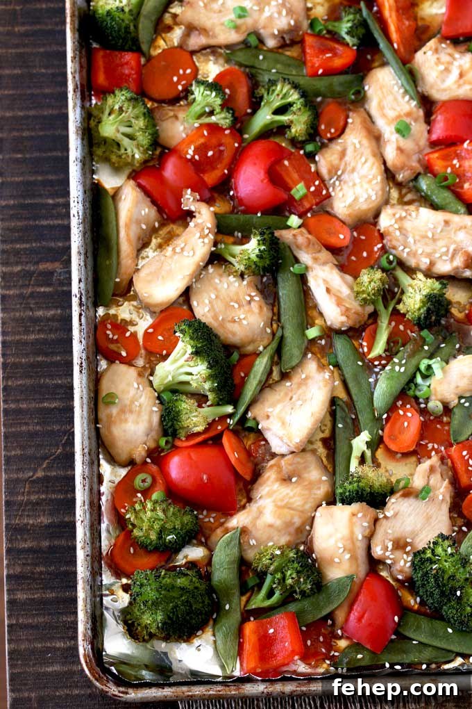 Sheet Pan Chicken and Vegetable Stir-Fry Recipe for Quick Dinners 5 Pictured here a sheet pan with Asian Chicken Stir Fry and vegetables, broccoli florets, red bell peppers, sliced carrots and sugar snap peas.