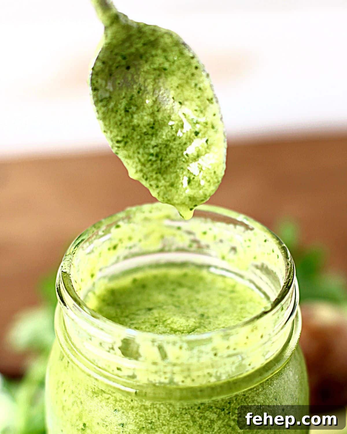 Spoon coming out of a jar of cilantro lime dressing.