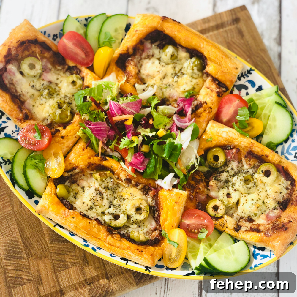 Gourmet Sausage Roll Recipe: Flaky Pastry with Savory Filling 3 homemade puff pastry pizzas topped with sun dried tomatoes, chopped ham, cheese and olives on a serving platter with fresh salad