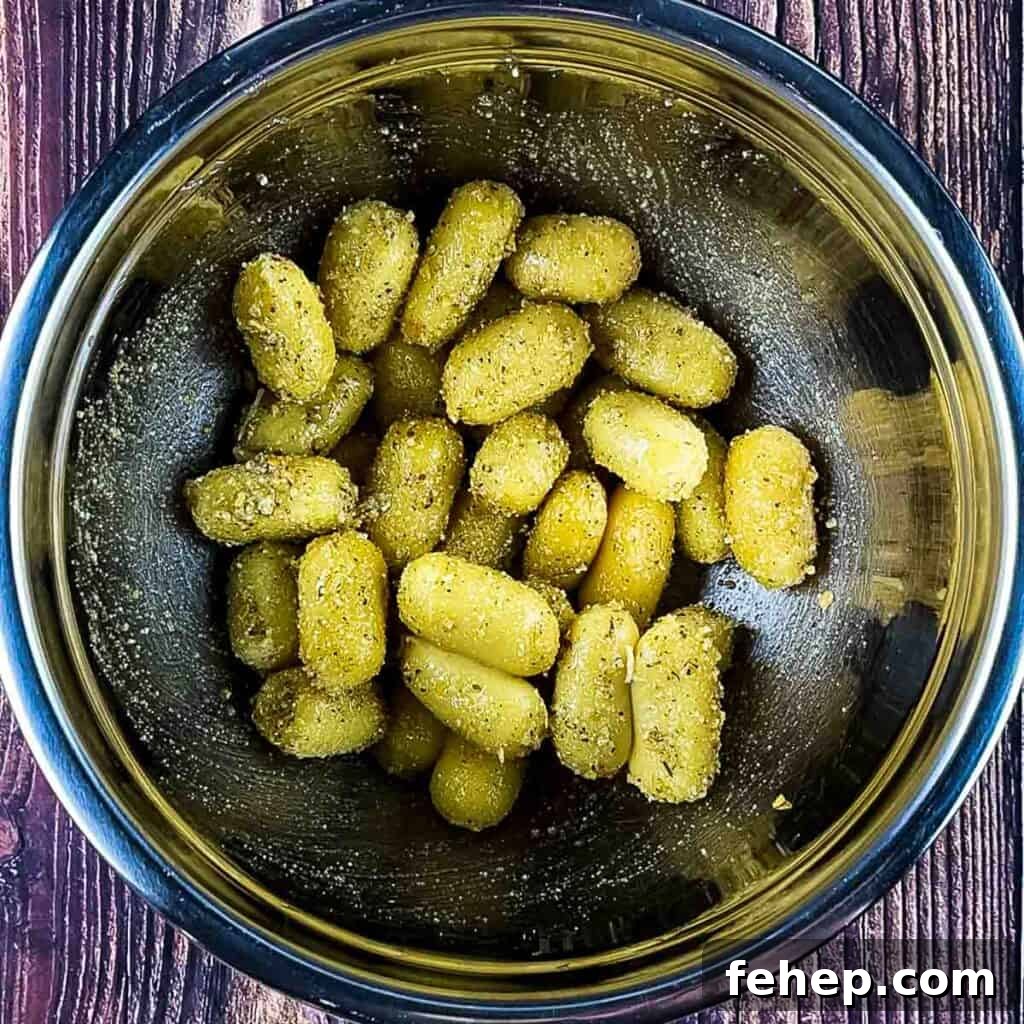 Crispy Air-Fried Gnocchi with Garlic Parmesan Crunch 5 Fresh gnocchi tossed in the seasoning mixture in a bowl.