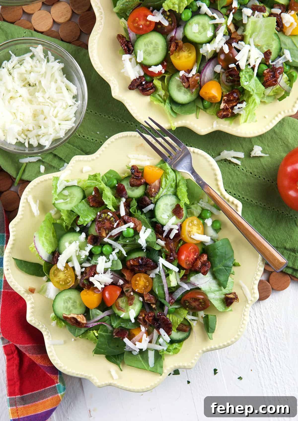 Overhead view of house salad on two plates with fork