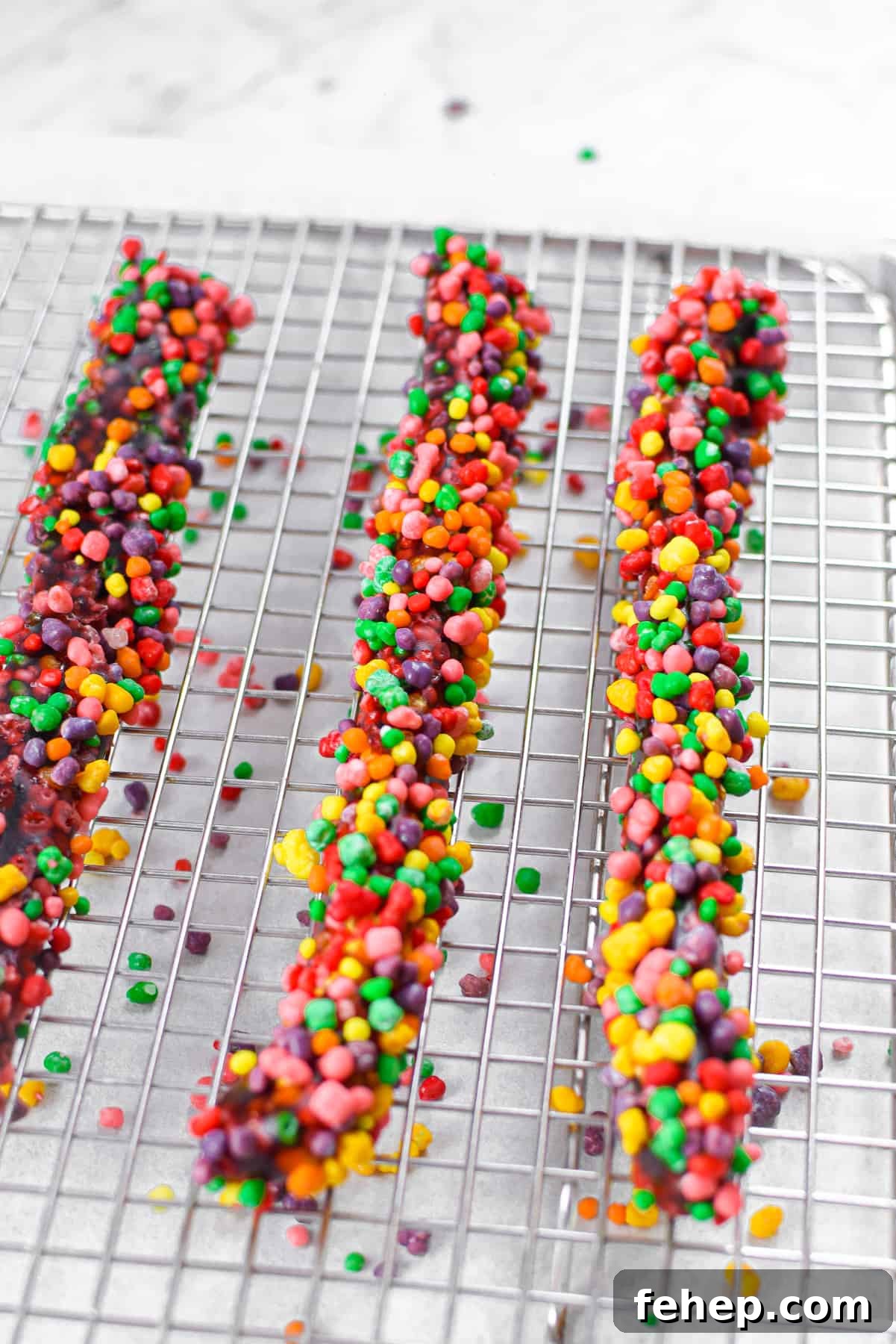 How to Make Cannabis-Infused Candy Ropes at Home 10 Three cannabis nerds ropes resting on a metal baking rack