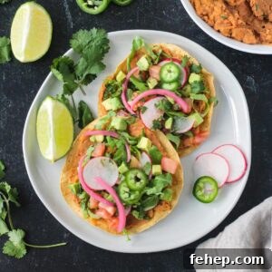 Vegan tostadas with refried beans and lots of toppings on a plate.