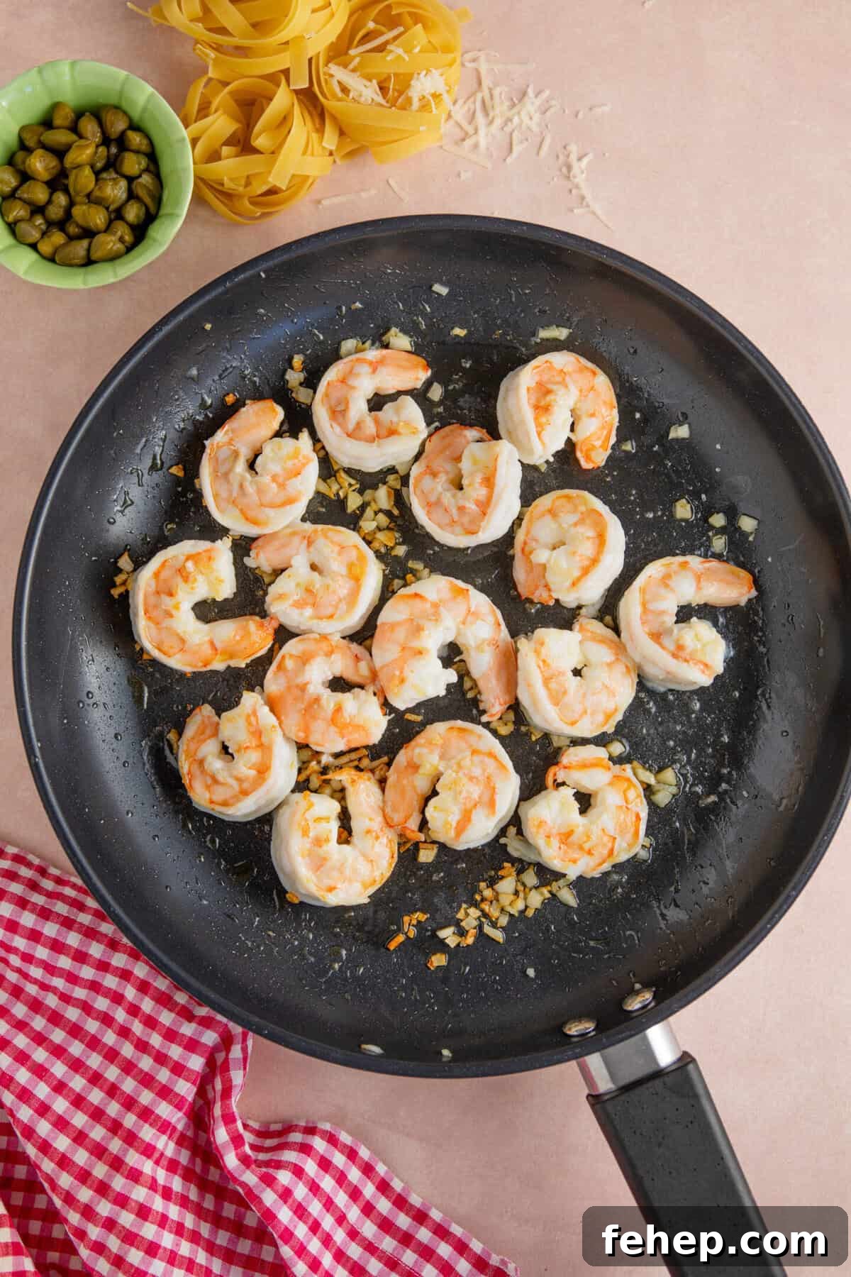 Creamy Garlic Prawn Pasta with Parmesan and Lemon 5 Cook the prawns and garlic in a frying pan.