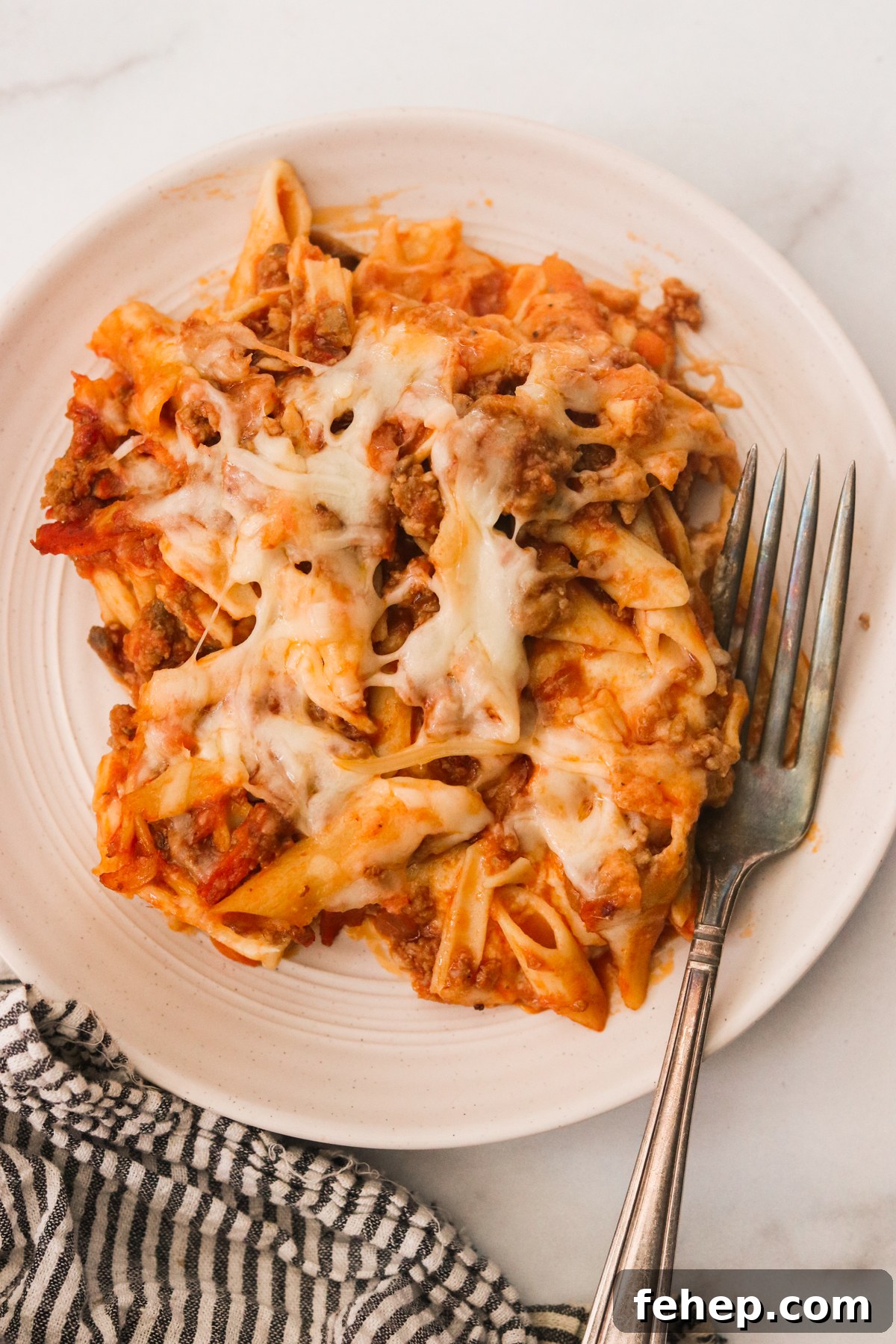25 Comforting Fall Dinner Ideas for Cozy Weeknight Meals 27 Plate with a serving of hidden veggie lasagna and a fork placed on a white countertop.