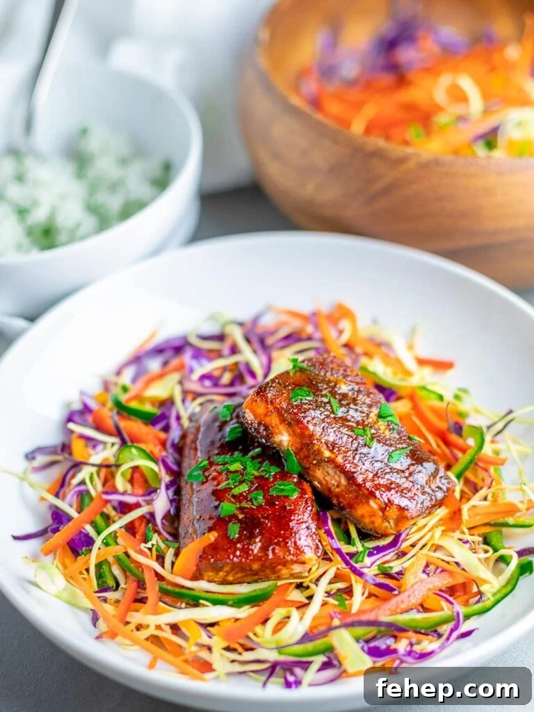 oven baked salmon with spice rub on rainbow salad in white bowl
