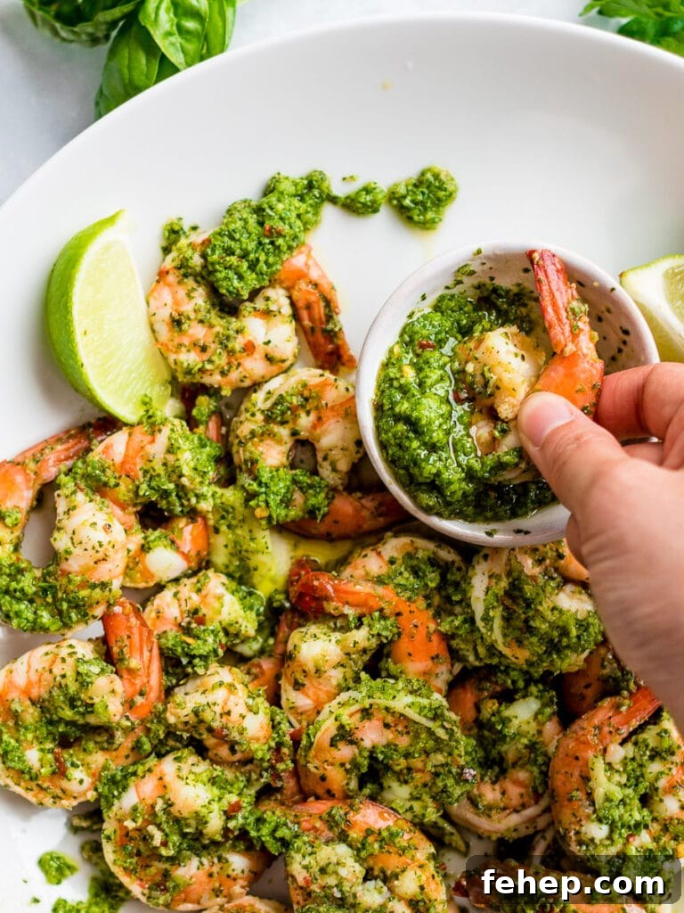 cilantro lime shrimp dipped in sauce on a white plate; copycat Costco cilantro lime shrimp