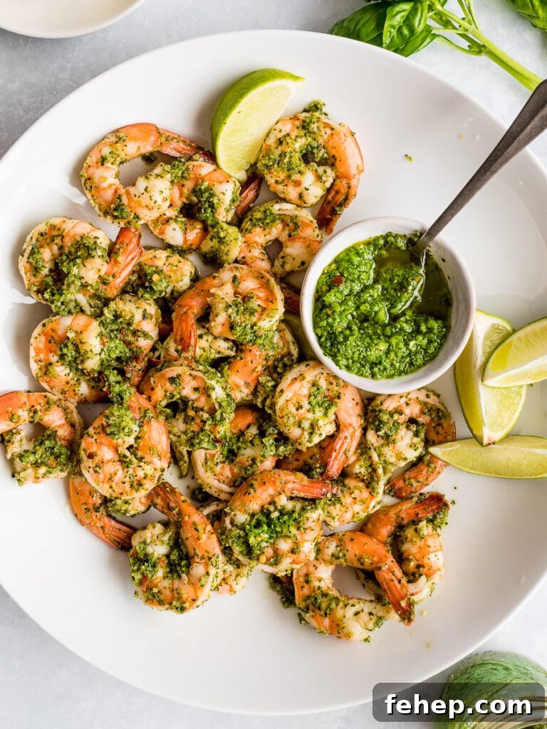 cilantro lime shrimp with a bowl of cilantro lime sauce on a white plate with lime wedges; low carb shrimp