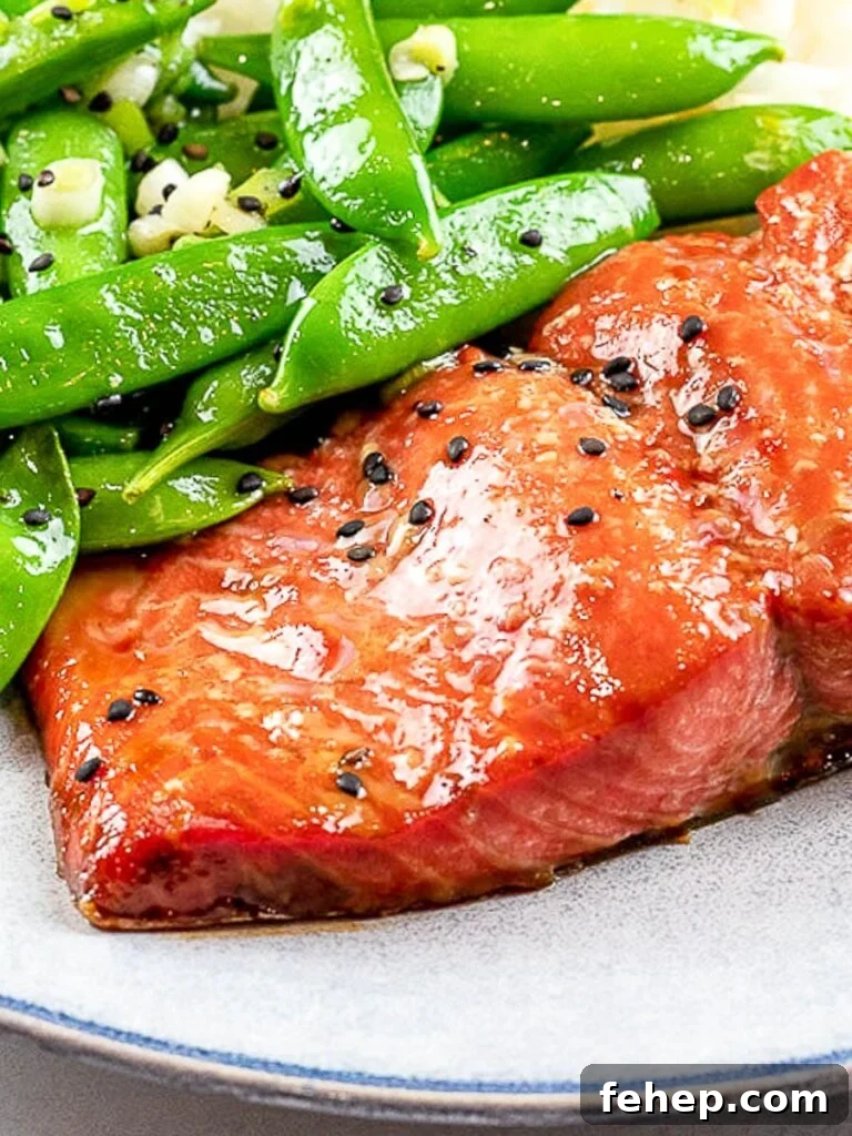 easy marinated and baked teriyaki salmon with sugar snap peas on a blue plate