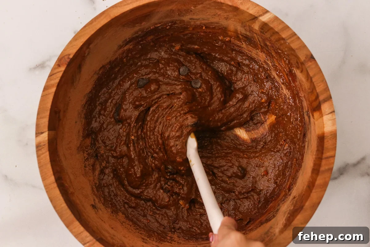 Chocolate chips being folded into the sweet potato brownie batter.