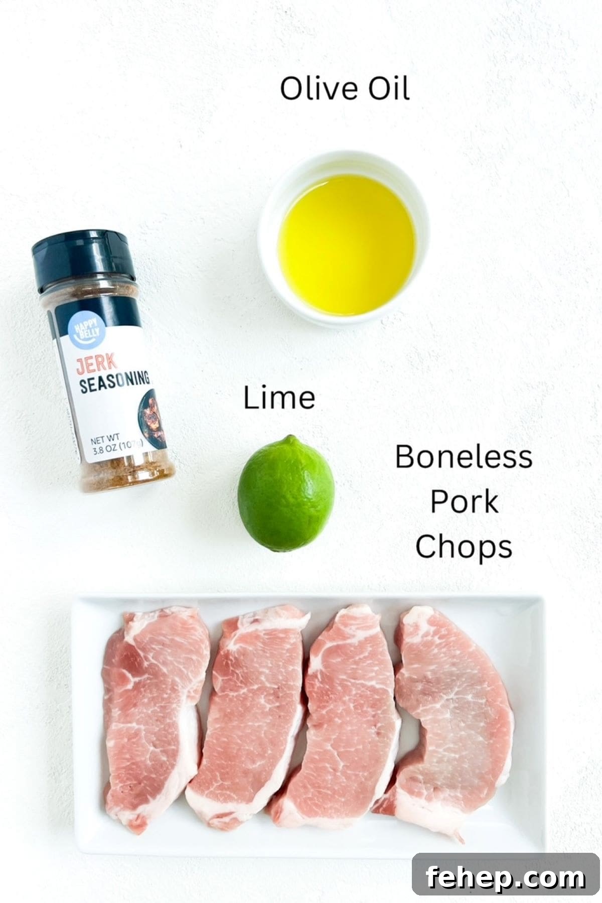 Four boneless pork chops, olive oil, one lime, labeled and a container of jerk seasoning on a white background.