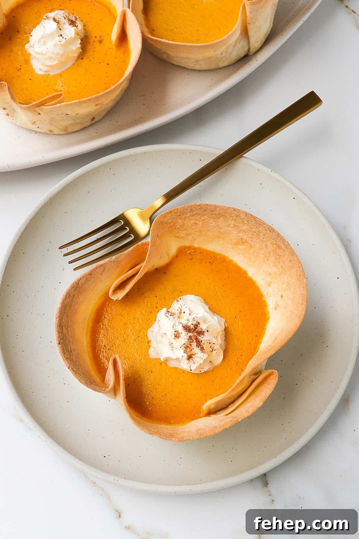Protein pumpkin pies served on a plate and plater with a gold fork.