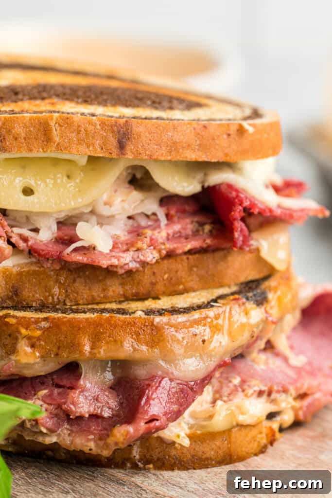 Classic Reuben Sandwich Recipe: Crispy Corned Beef & Melted Swiss 2 closeup of two reuben sandwiches stacked